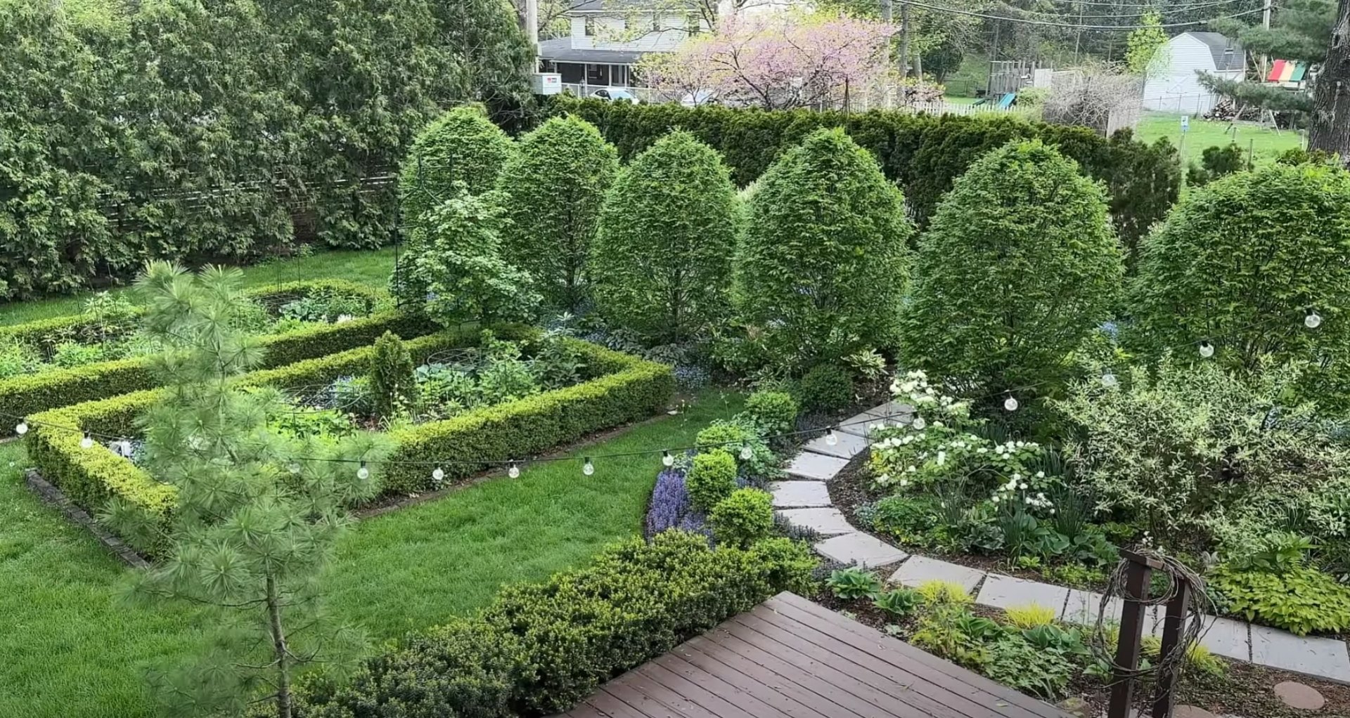Aerial view of formal garden design with geometric hedges, manicured lawn, and decorative lighting
